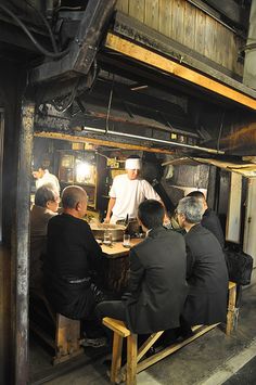 several men sitting at a table in an old building