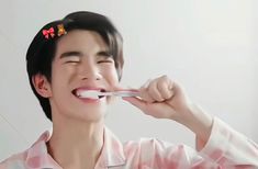 a young man brushing his teeth with an electric toothbrush