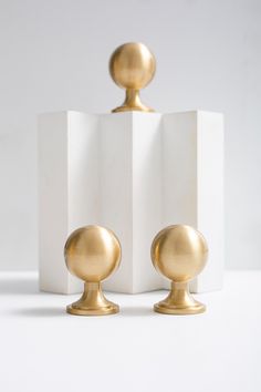 two white and gold vases sitting next to each other on top of a table