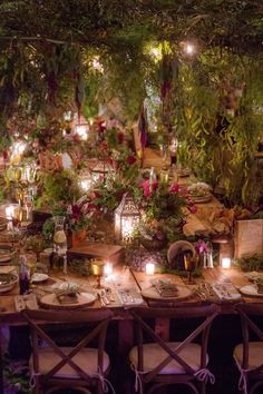 a table set up with candles and flowers in the center for an outdoor dinner party