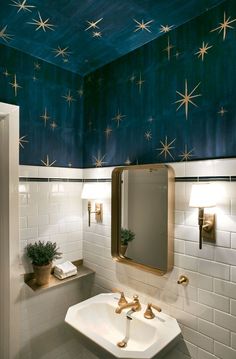 a white sink sitting under a bathroom mirror