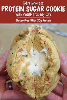 a hand holding a cookie with white frosting and sprinkles