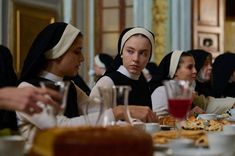 a group of women sitting at a table with food