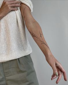 a woman's arm with a tattoo on it and her hand holding the wrist