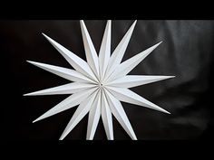 a white paper snowflake sitting on top of a black surface