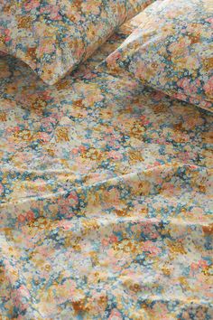 an image of a bed with floral sheets and pillowcases on top of it