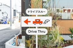 a street sign in front of a building with japanese writing on it and an arrow pointing to the left