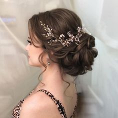 a woman wearing a tiara with flowers in it's hair is looking away from the camera