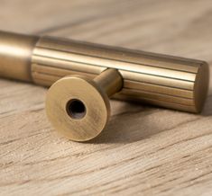 a brass cylinder on a wooden surface