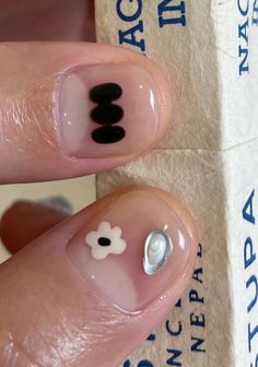 a person with black and white nail designs on their nails, next to a cardboard box