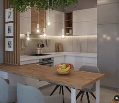 a bowl of fruit sitting on top of a wooden table next to a kitchen counter