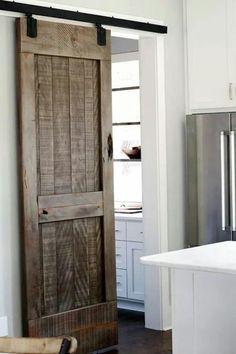 an open wooden door in a white kitchen