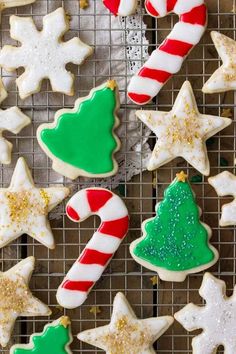 christmas cookies on a cooling rack with candy canes and star shaped cookies in the background