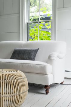 a white couch sitting on top of a wooden floor