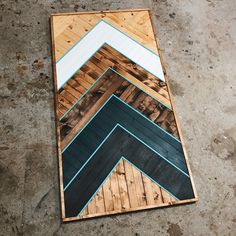 a wooden board with different colors and patterns on it's sides, laying on the ground