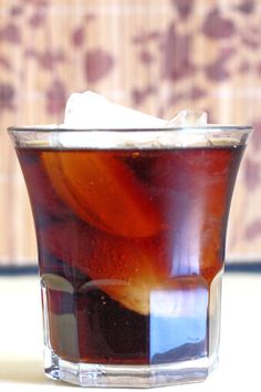 a glass filled with liquid sitting on top of a table