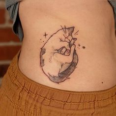 a woman's stomach with a cat tattoo on her belly and the bottom half of her stomach