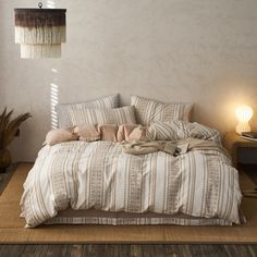 a large bed sitting on top of a wooden floor next to a lamp and table