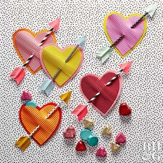 three heart shaped pins are on a white surface with small hearts attached to the pins