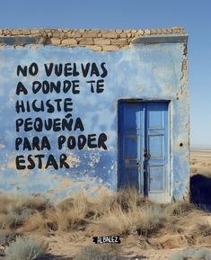 a blue building with writing on it in the desert