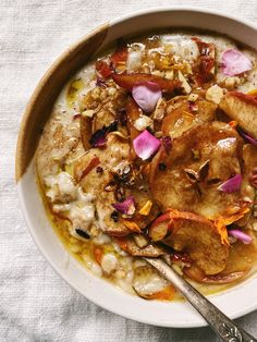 a bowl filled with oatmeal and fruit on top of a white cloth