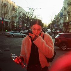 a woman is standing on the street eating something