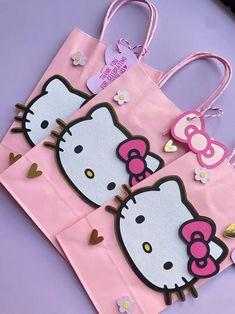 two hello kitty bags are sitting on a table