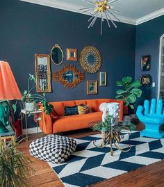 a living room with blue walls, orange couches and black and white checkered rug