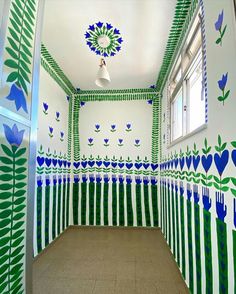 an empty room with blue flowers painted on the walls and green leaves drawn on the wall