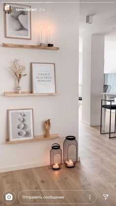 two candles are sitting on the wall next to some pictures and other things in front of them