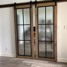 two double doors with glass and wood frames in an empty room