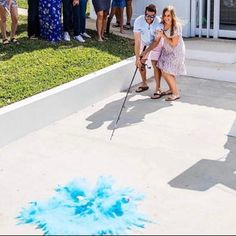 a man and woman playing golf with blue powder