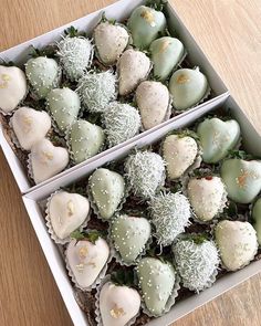 two boxes filled with assorted chocolate covered strawberries on top of a wooden table