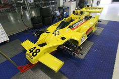 a yellow race car sitting on top of a blue mat