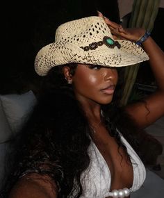 a woman wearing a white top and a straw hat