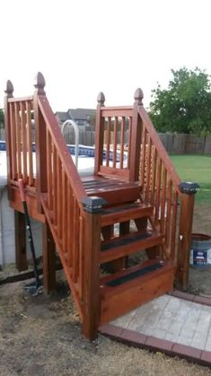 a wooden stair case next to a swimming pool