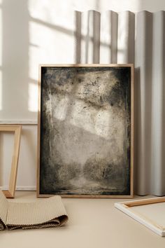 an old photo frame sitting on top of a table next to some books and pencils