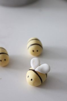 three small bees sitting on top of a white table