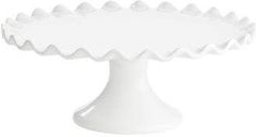 a white cake plate with scalloped edges on an isolated pedestal, viewed from the front