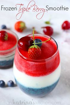 two glasses filled with fruit and yogurt sitting on top of a white table