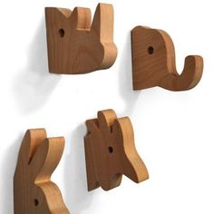 three wooden elephant hooks hang on the wall next to each other in different shapes and sizes