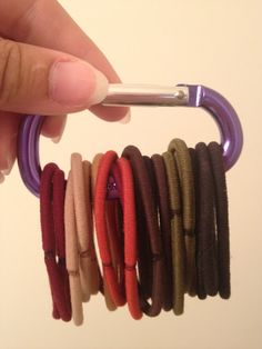 a person is holding several different colored bracelets with a toothbrush in their hand