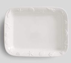 an empty white plate with writing on the front and bottom, against a gray background