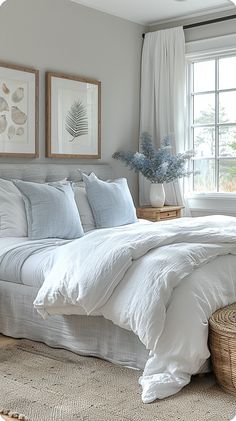 a bed with white linens and pillows in a bedroom next to a basket on the floor