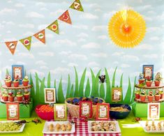 a table topped with lots of food on top of a green table covered in grass