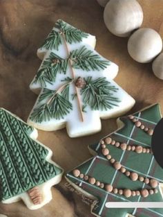 three decorated christmas cookies sitting on top of a table