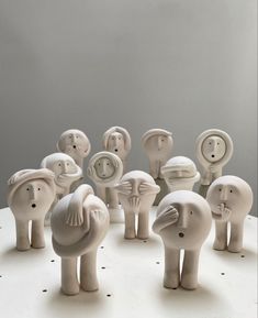 a group of ceramic elephants standing on top of a white table