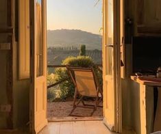 an open door leading into a bedroom with a chair in the doorway and mountains in the background