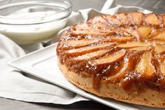 a pineapple upside down cake on a plate next to a bowl of yogurt