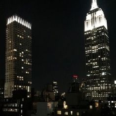 two skyscrapers lit up at night in the city